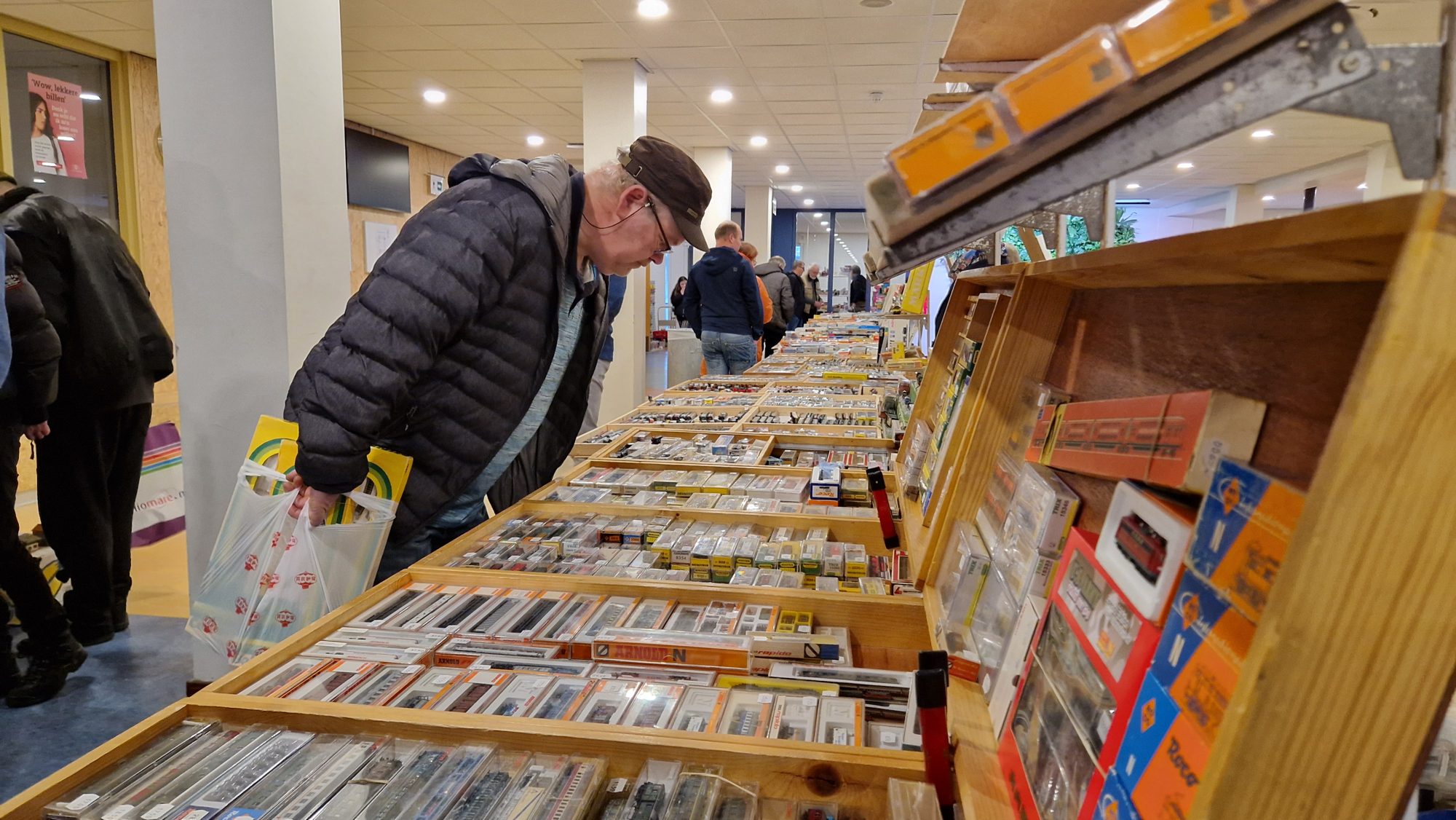Een bezoeker zoekt tussen de dozen op de treinenbeurs
